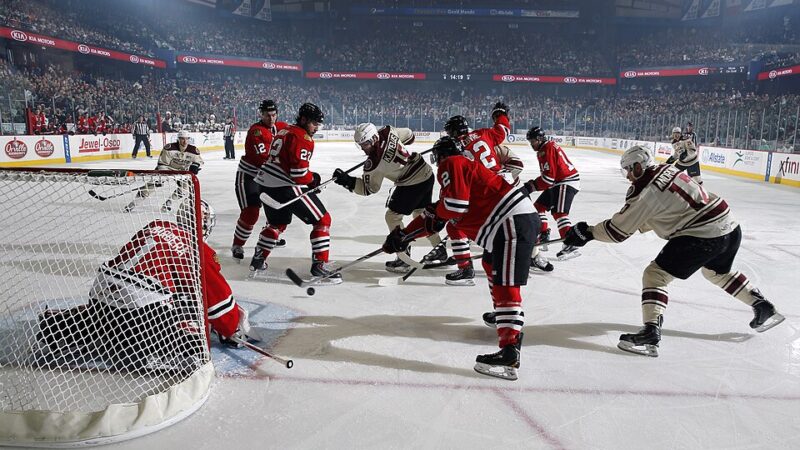 Ice hockey faceoff action with players battling in front of the goal net