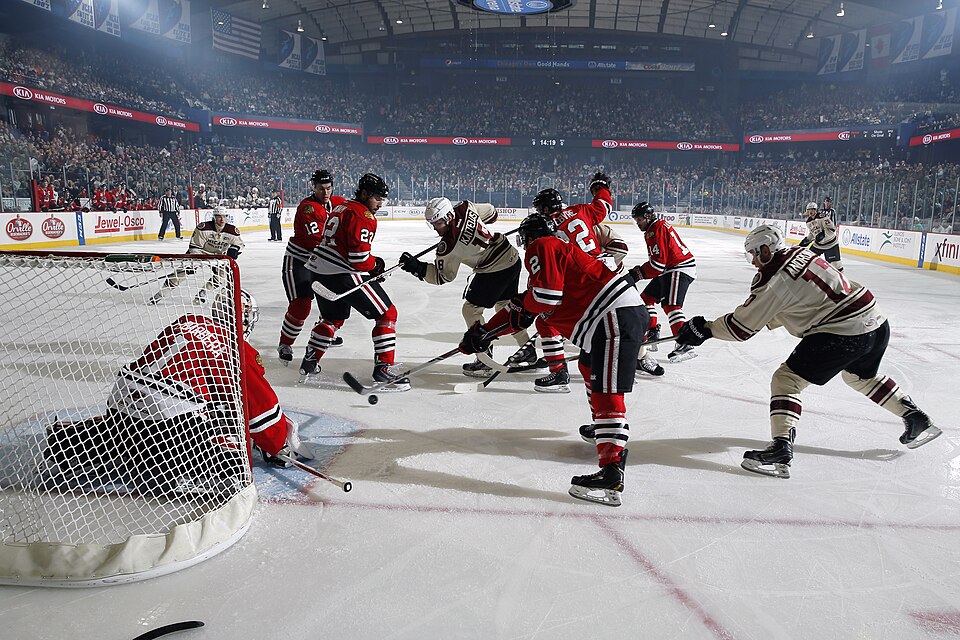 Ice hockey faceoff action with players battling in front of the goal net