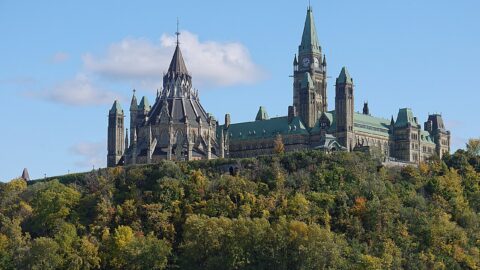 Parliament Hill and the Peace Tower seen across the Ottawa River in autumn